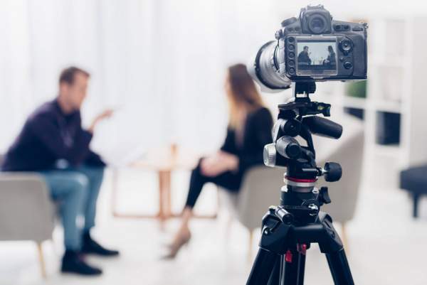 Une femme et un homme en train de filmer une vidéo dans le cadre d’une stratégie marketing